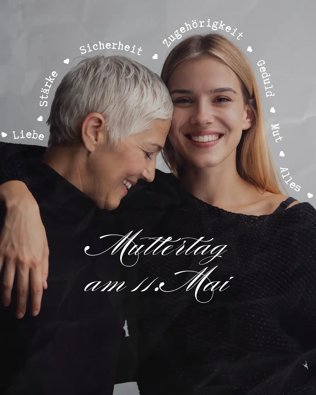 Alt-Text: Zwei Frauen, eine ältere mit grauem Haar und eine jüngere mit langen blonden Haaren, umarmen sich lächelnd. Im Hintergrund sind Begriffe wie "Liebe", "Stärke" und "Zugehörigkeit" angeordnet. Der Text "Muttertag am 11. Mai" ist prominent in der Mitte platziert. Das Bild vermittelt eine herzliche Verbindung zwischen Mutter und Tochter.