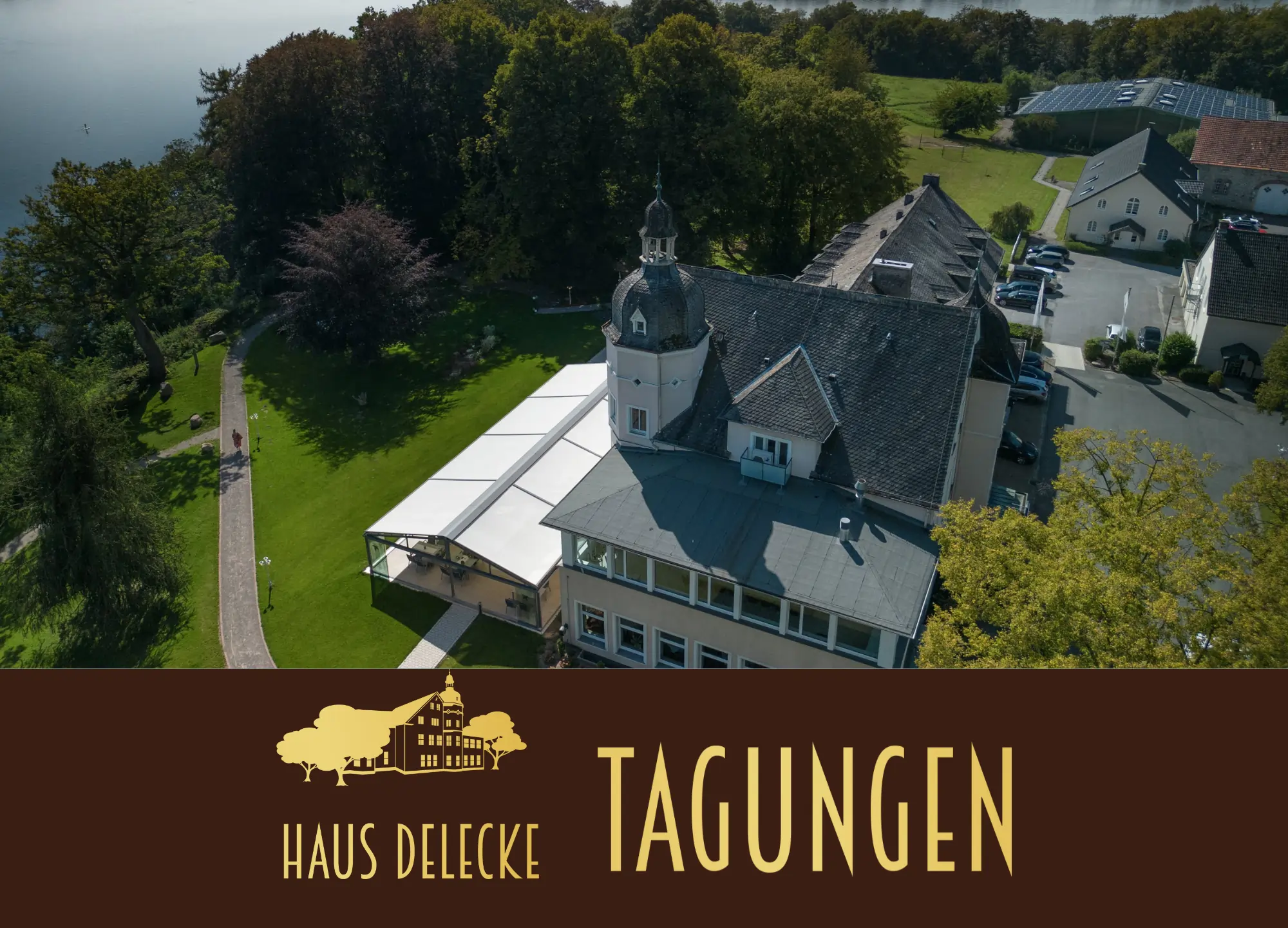 Tagungsprospekt Cover Foto. Haus Delecke als Luftaufnahme. Terrasse mit Park und dem Möhnesee im Hintergrund.