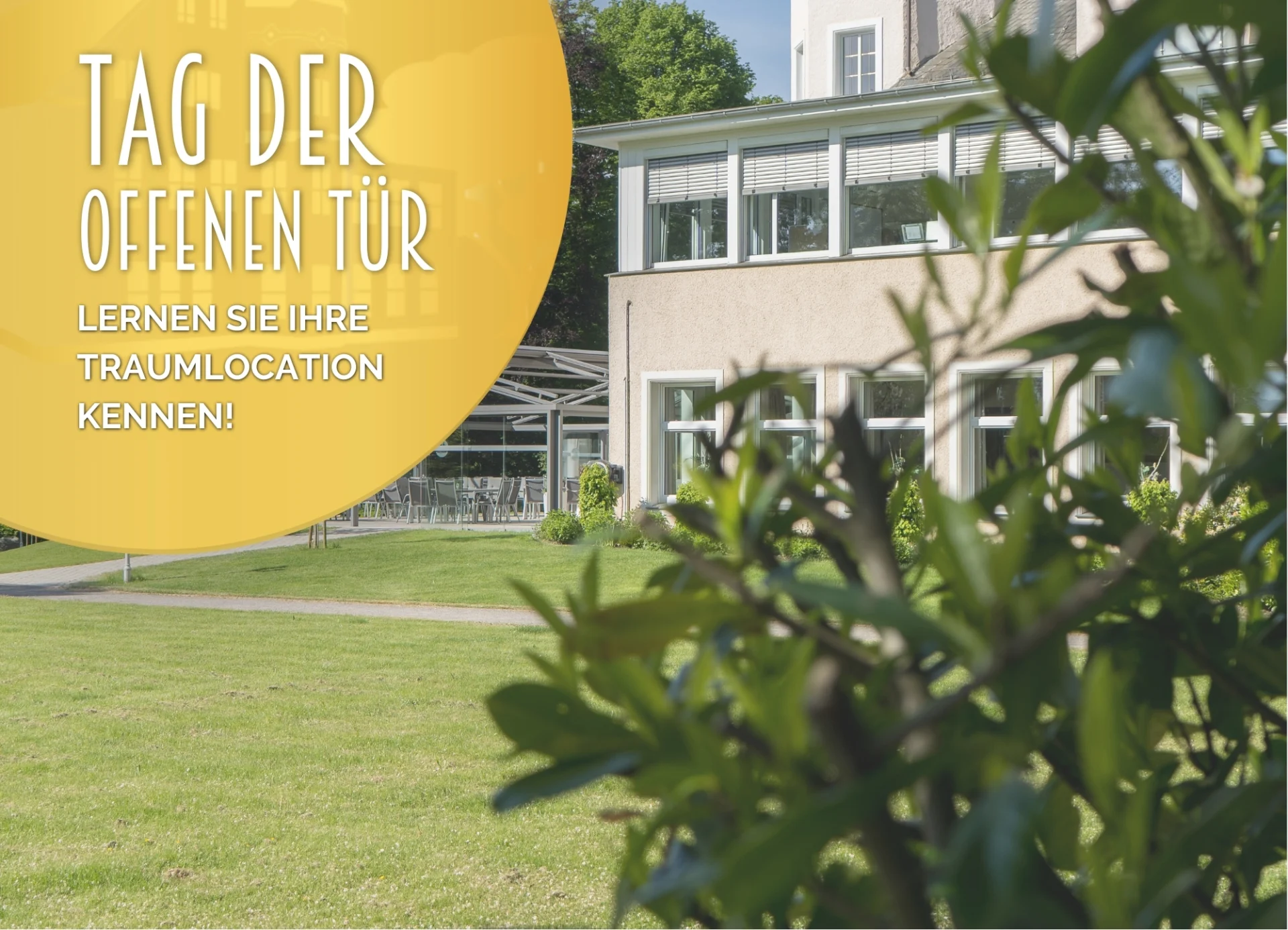 Yellow banner with the words ‘Open Day – Discover your dream location!’ in front of a modern building with large windows. In the foreground, green plants frame a well-tended lawn. In the background, blue sky stretches above the trees.