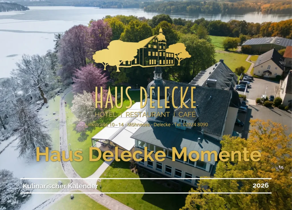 Omslagfoto van de culinaire kalender 2026. Haus Delecke vanuit vogelperspectief. Op de achtergrond het meer. De foto gaat langzaam over van winter met besneeuwde bomen en een bevroren meer naar zomer met groene bomen.